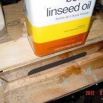 The linseed oil and a scrap piece of wood were used to hold the blocks down during their soak.